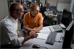 In this photo, two scientists are looking at secondary ion mass spectrometry (SIMS) data on the instrument computer screens.