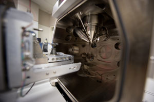 This photo is a view of the inside of  an electron microscope, with multiple lenses focused on a single point. The image shows the bottom of the lenses of both the scanning electron microscope and the ion microscope, hence the dual beam configuration of the instrument.  