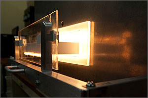 In this photo, the cavity inside the furnace is glowing white-hot during a simulated firing, while a drawer-like door is open to show the mouth of the furnace.