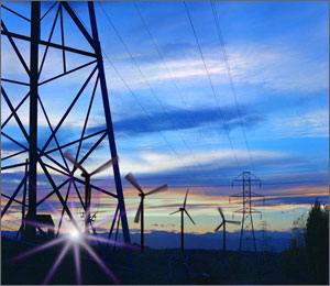 Photo of electric transmission lines with large wind turbines in the background.
