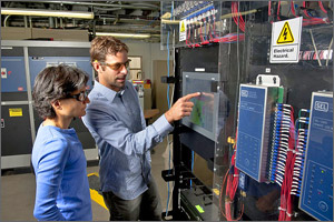 Photo of two NREL staff looking at display equipment. 