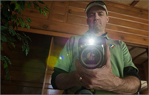 Photo of a man directing a light beam and heat sampling tool at the camera. 