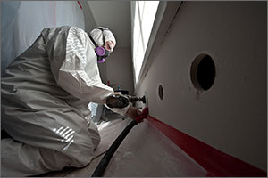 Photo of a man working in protective clothing in a home.