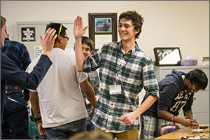 Photo of two high school students high-fiving each other.