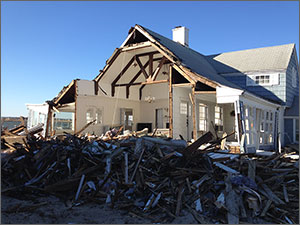 Photo of a heavily damaged home with the front wall missing.