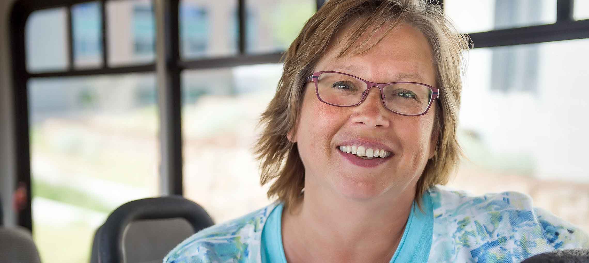 Photo of a woman sitting in an alternative-fueled bus.