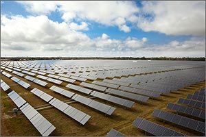 Photo of numerous rows and columns of solar modules tilted at about a 40 degree angle toward the sun.