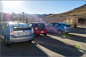 Photo of three vehicles parked in the sun the with NREL campus in the background.