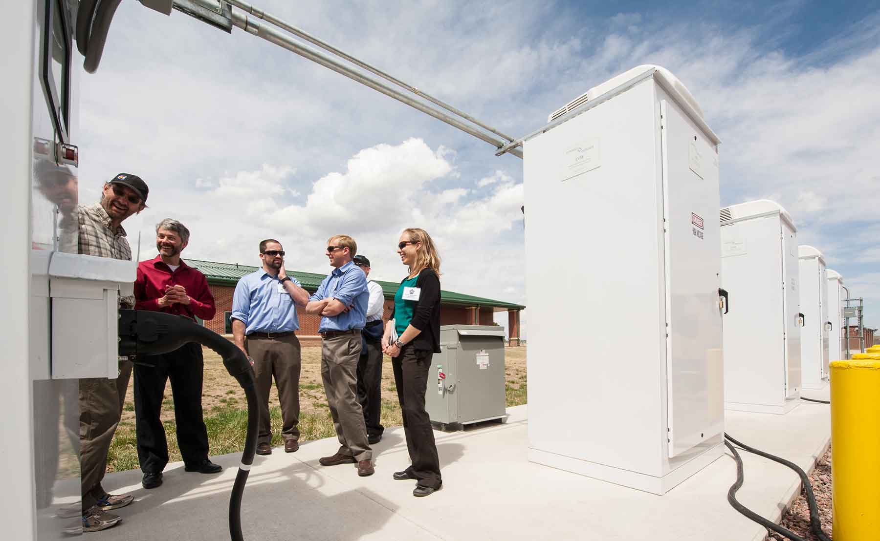 A group of researchers from NREL examines a piece of equipment at an Army base.