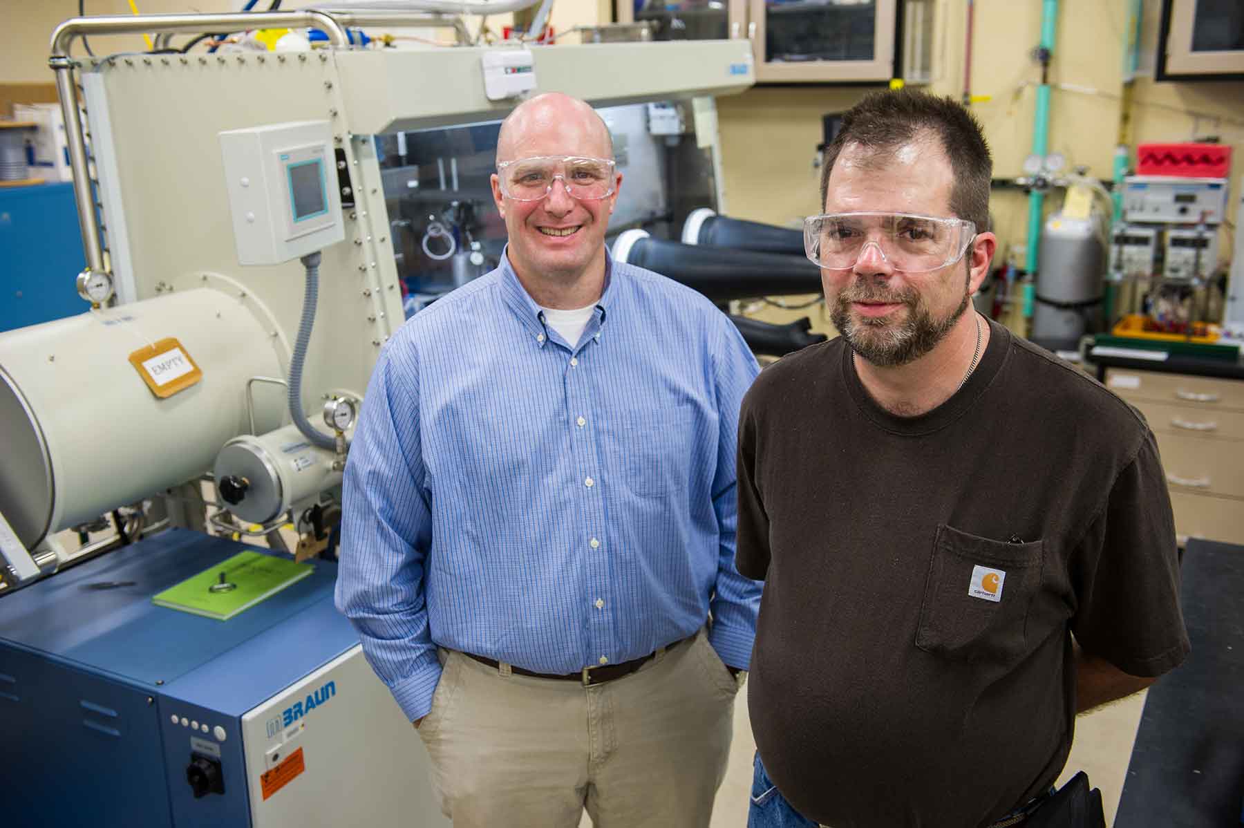 Two NREL researchers stand in a lab.