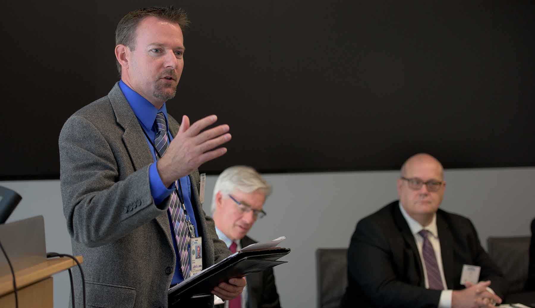 Man stands in front of an audience.