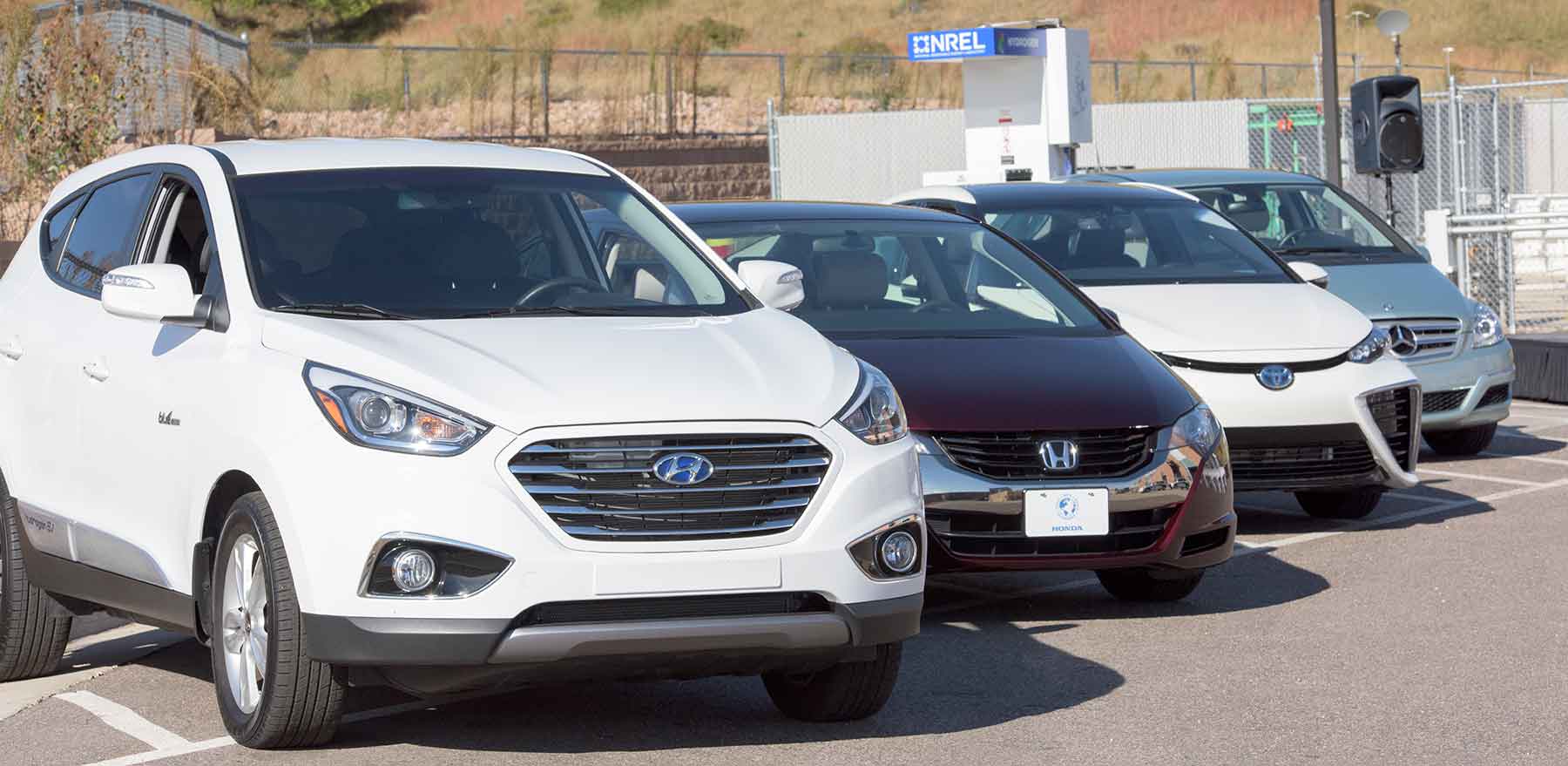 Four cars are parked near a hydrogen fueling station at NREL.