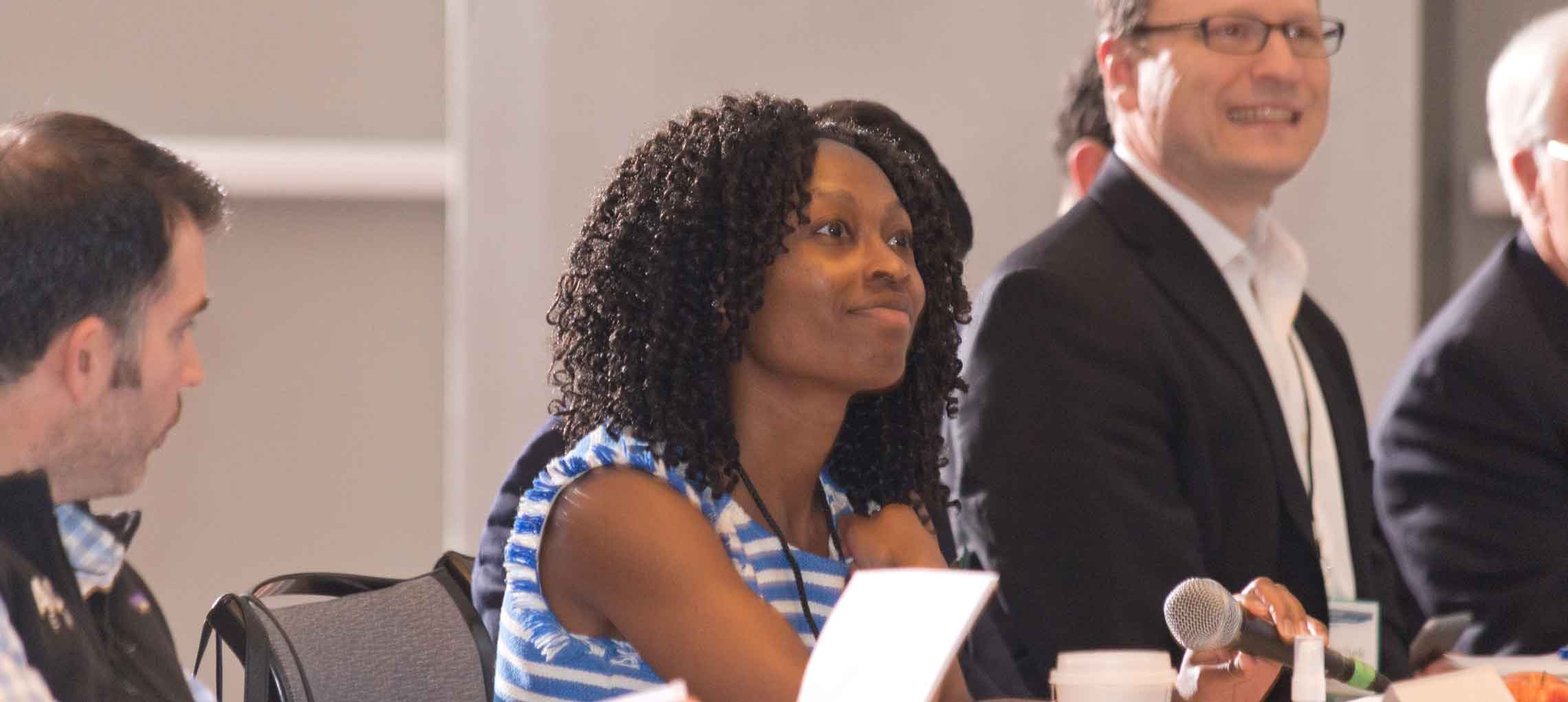 Photo of a group of people sitting and listening to an entrepreneur speaking.