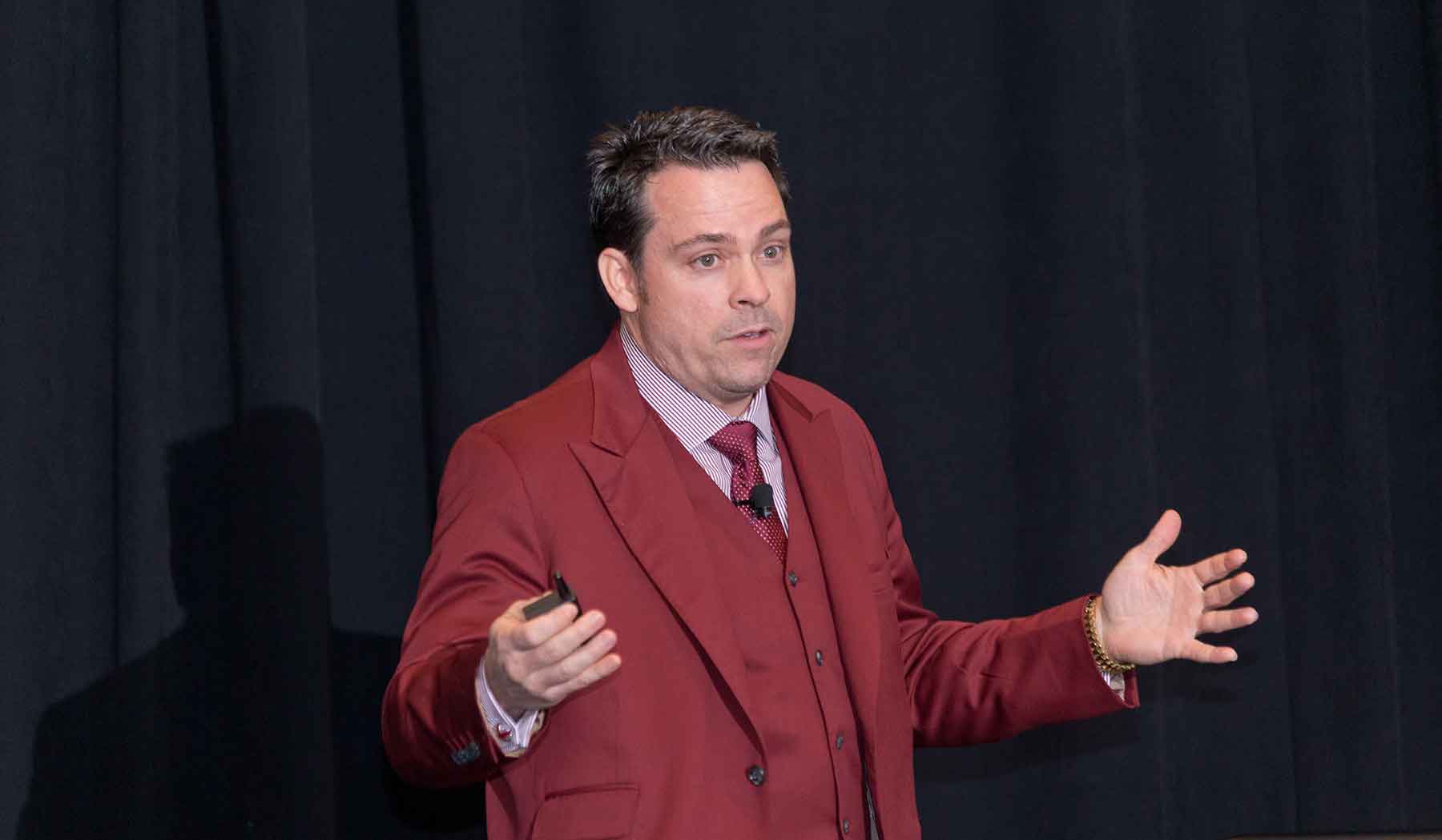 Photo of a man standing on a stage giving a speech.