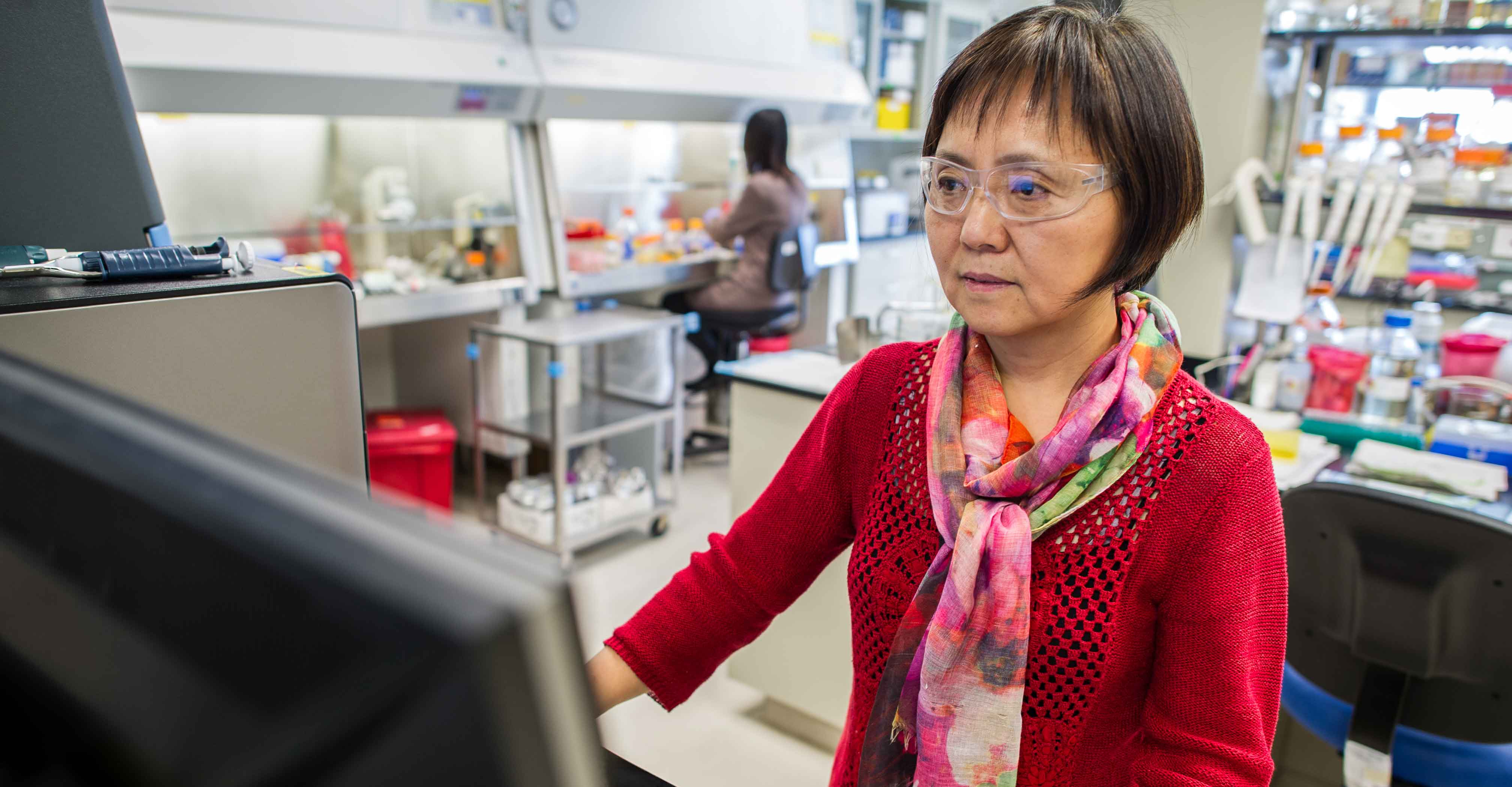 A woman at a computer in a lab.