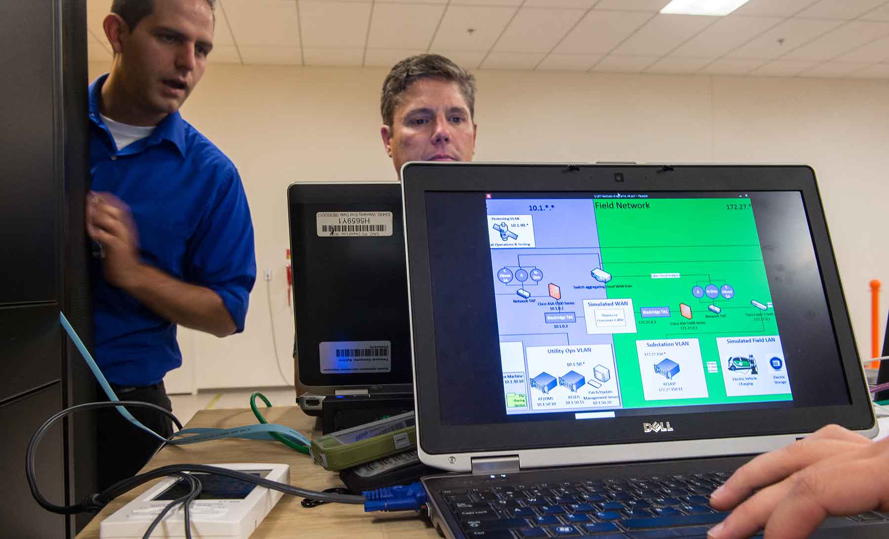 Photo of two men and a computer screen.