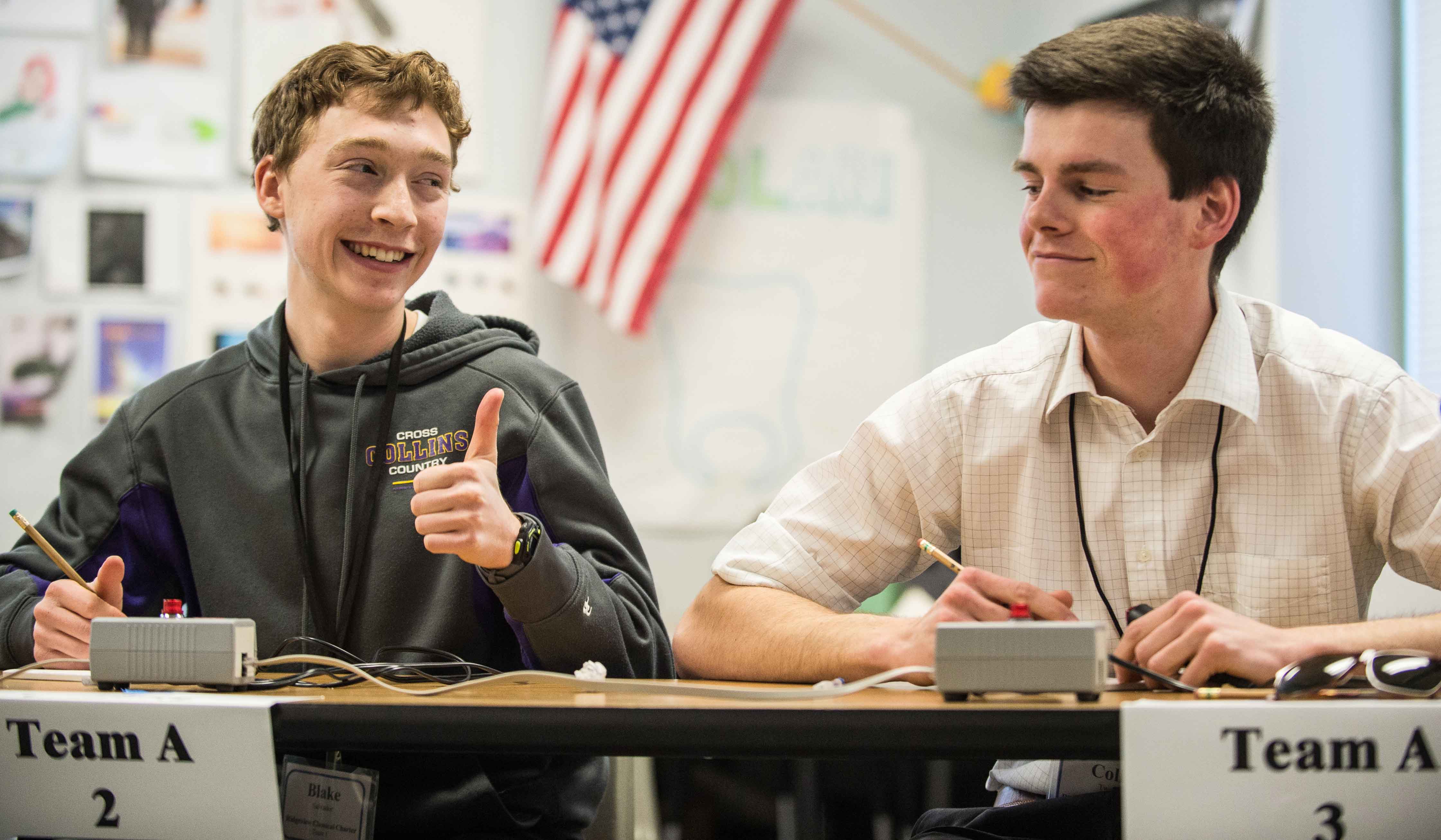 One student from a team gives another the 'thumbs up' sign after answering a question correctly.