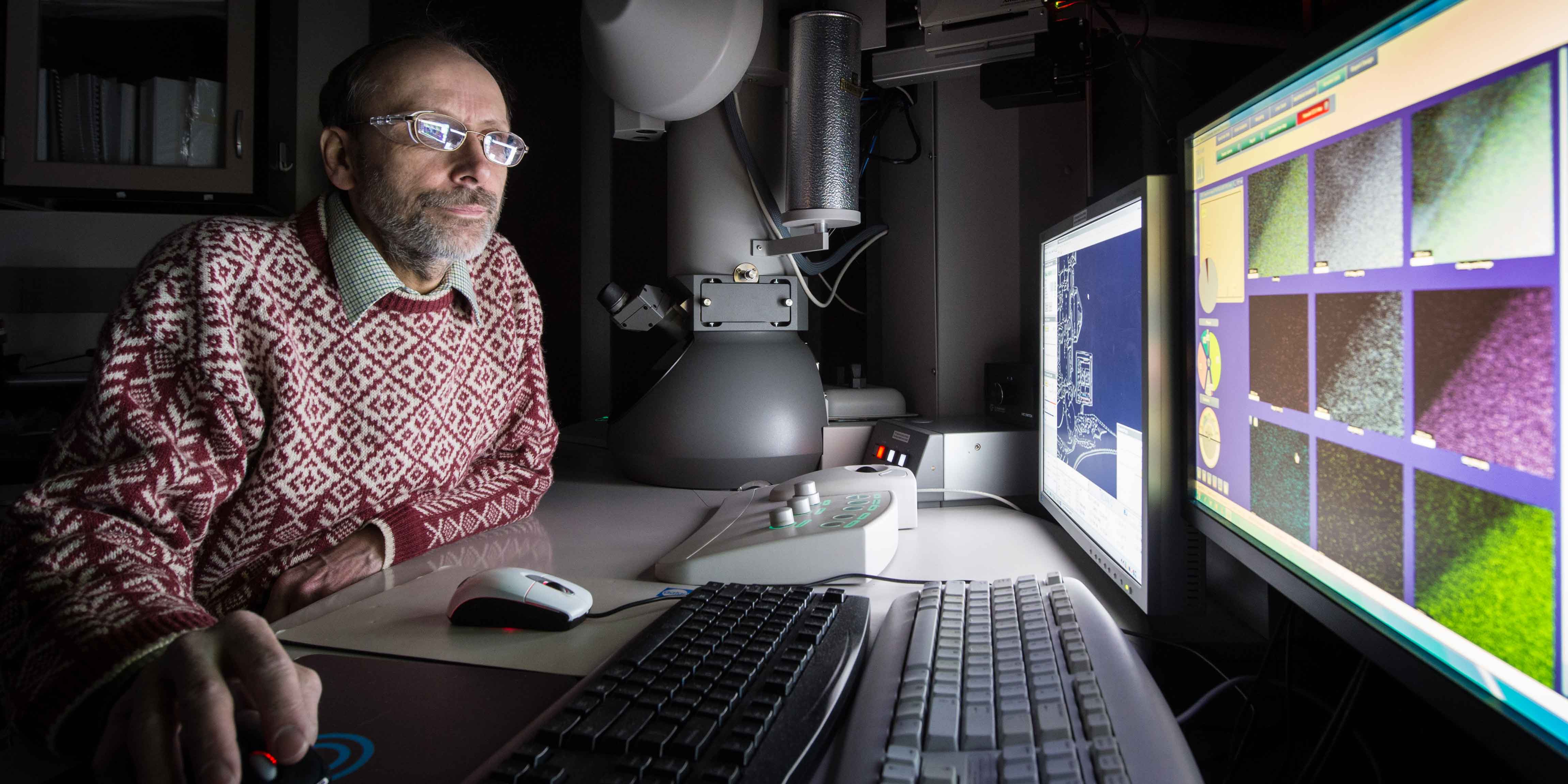 A man looks at images through a scanning transmission electronic microscope.