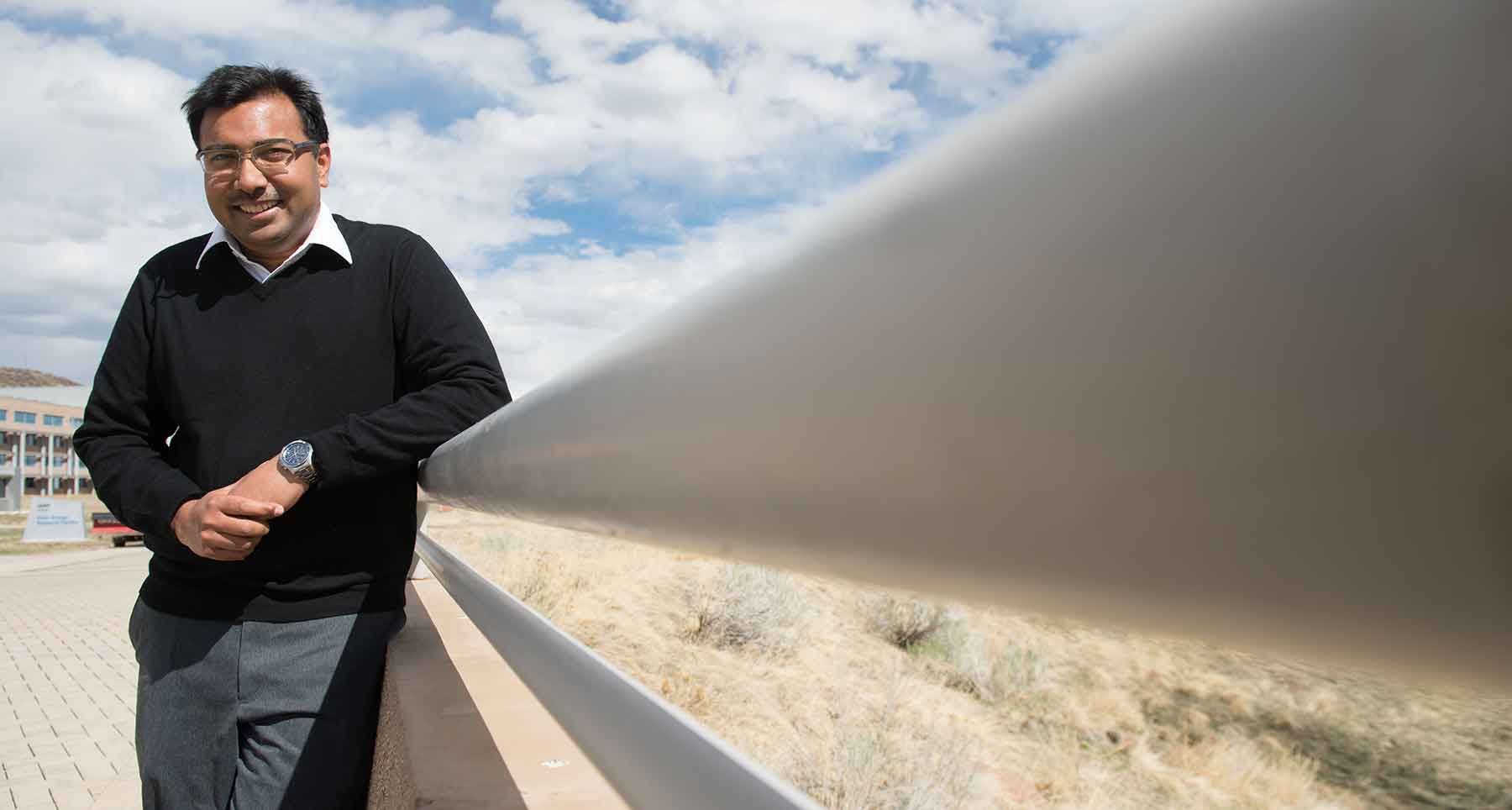 A man leans against a railing.