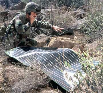 A soldier with a PV flexible portable power pack in a field.