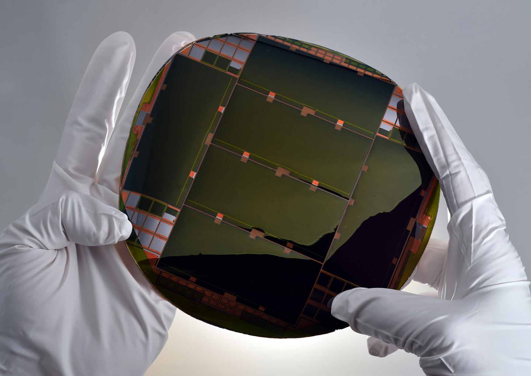 Two hands holding the IMM solar cell