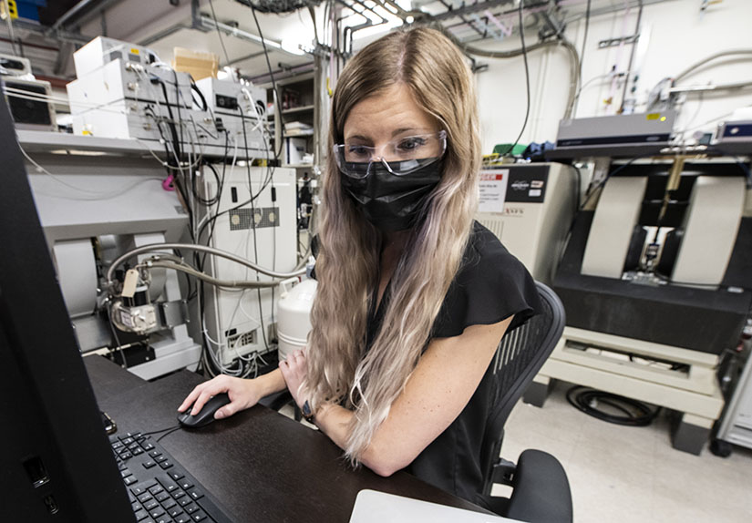 Photo of a woman working at a computer in a laboratory.