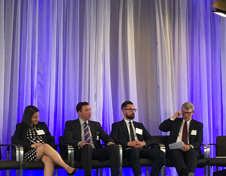 Four panelists seated on stage.