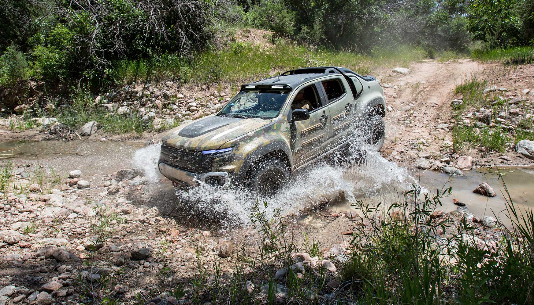 The GM Chevy Colorado ZH2 drives through a stream on the Fort Carson Army Base.