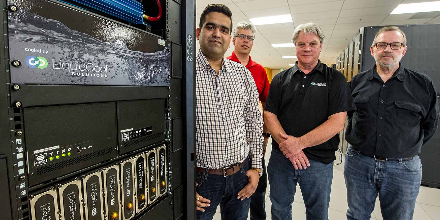 NREL researchers and LiquidCool Solutions representatives stand along-side LiquidCool's server cooling technology.