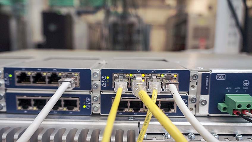 Schweitzer Engineering Laboratories hardware equipment with white and yellow cords in research facility.