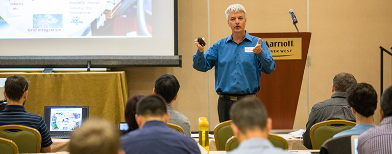 Photo of a researcher lecturing in an auditorium.