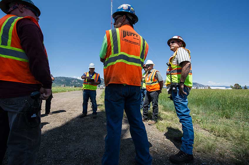 A group of workers discuss safety plans at the NWTC