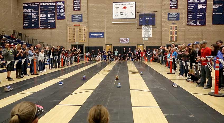 Image of rubber race tracks surrounded by people