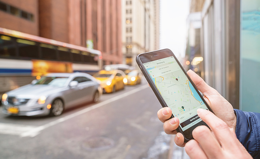 Person on cell phone using ride-hailing app showing map