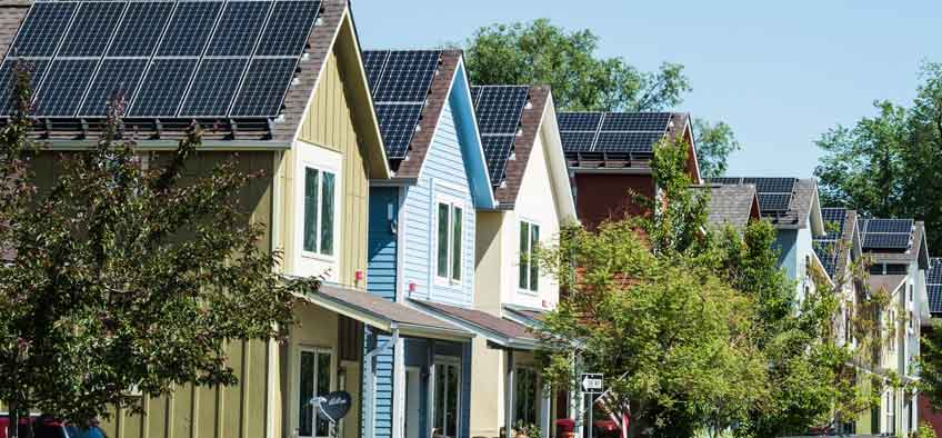 Neighborhood of houses with rooftop solar panels.