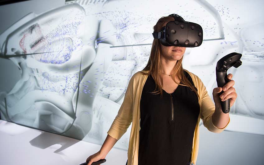 A woman wearing virtual reality glasses tests a simulation