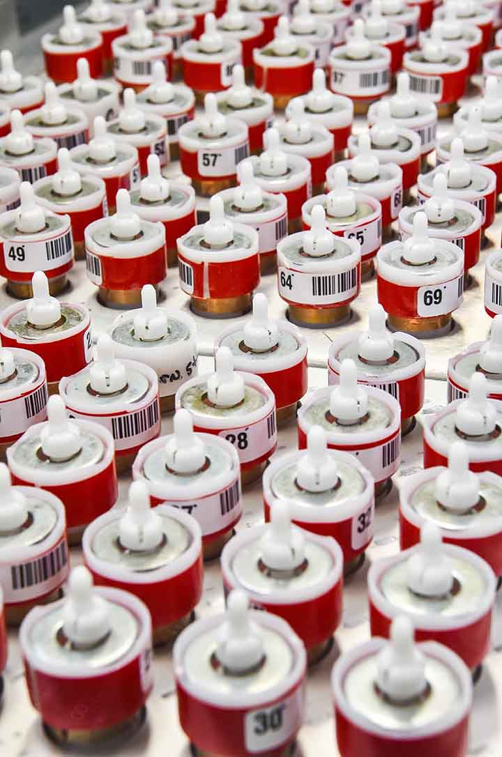 Small red cylindrical containers that are numbered and positioned in several rows.