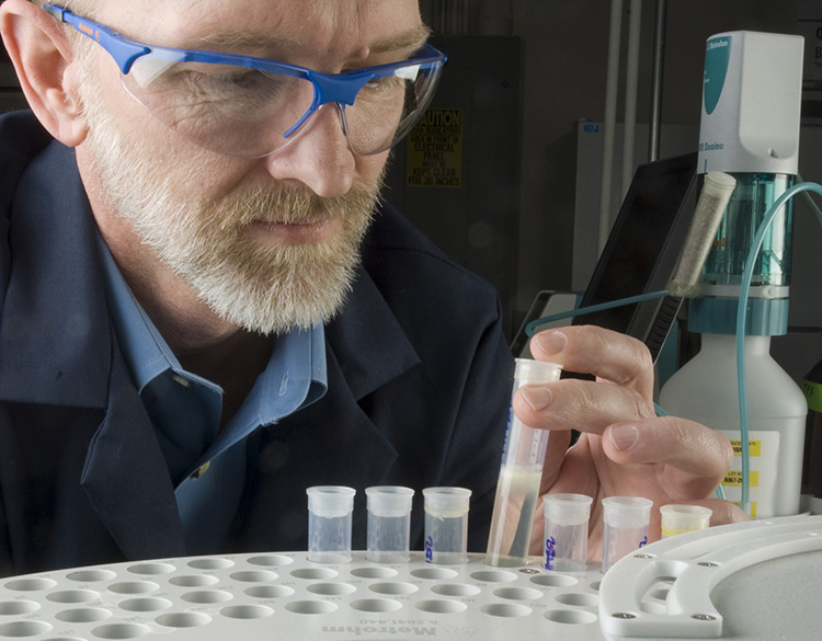 A man examines a biodiesel sample in NREL's Fuel Chemistry Laboratory.