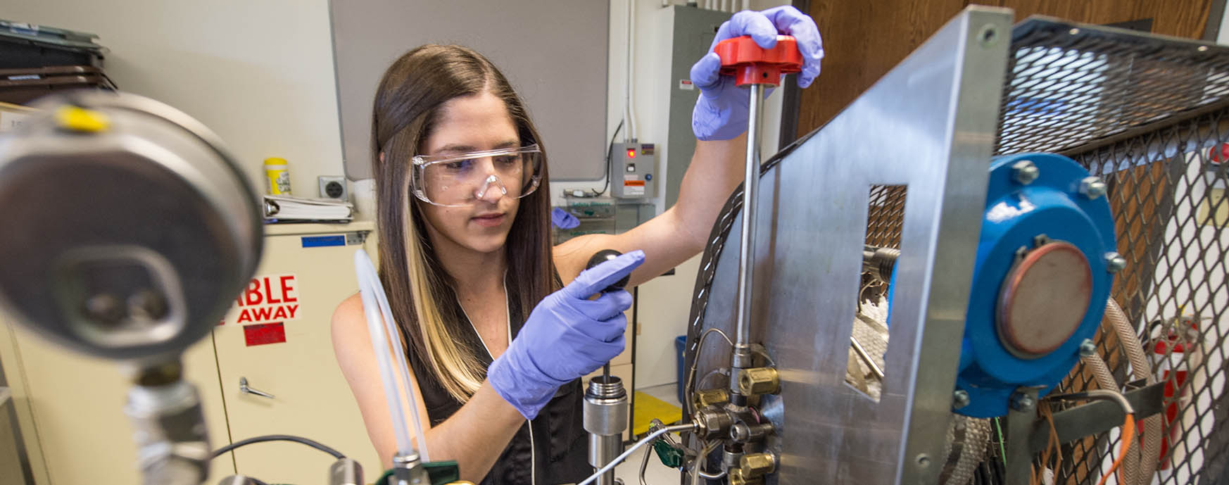 Woman preparing a fuel evaluation in a constant volume combustion vessel