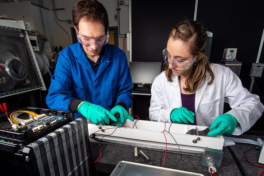 Photo of researchers in laboratory setting working with technical components.