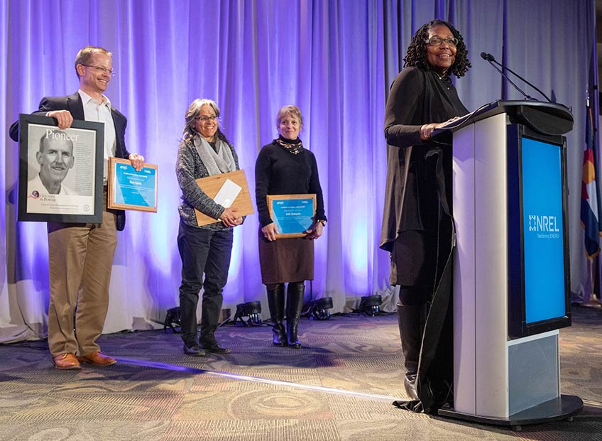 NREL Project Development and Finance team members accept their award for outstanding support of federal energy infrastructure projects.