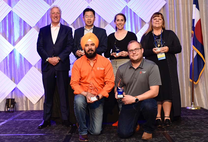 Six people pose for an award photo.