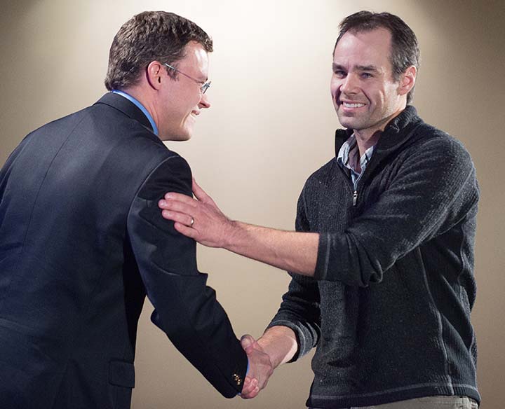 Two men shaking hands and smiling