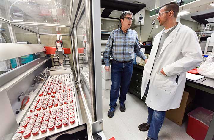 Two men talking in a laboratory.