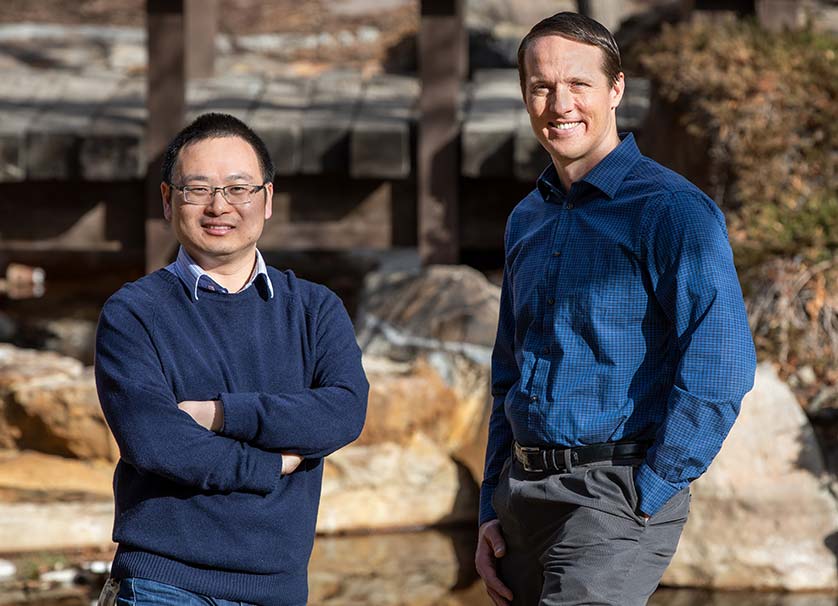 Two men stand outdoors.