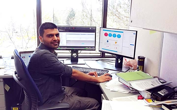 Researcher works at his computer at his office desk