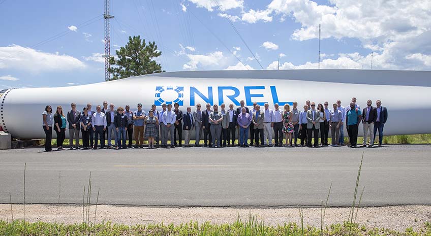 Group in front of wind turbine blade.