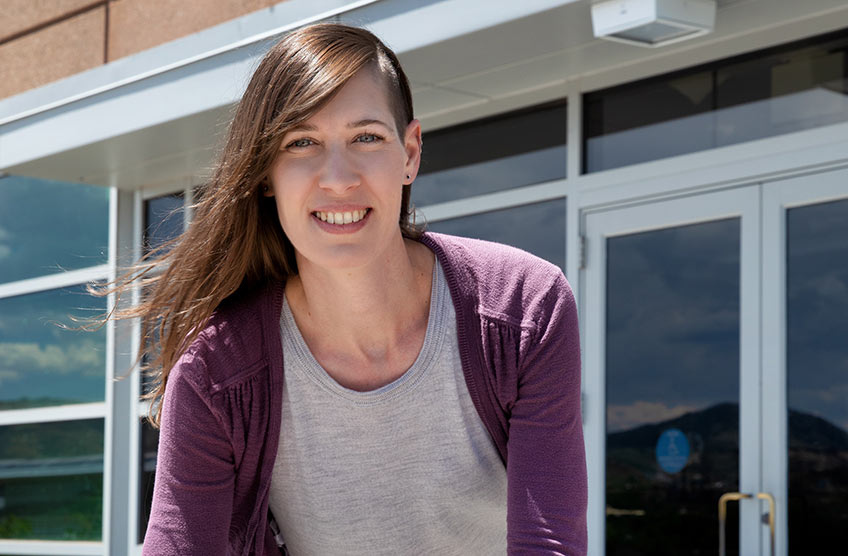 A woman stands outisde a building at NREL.