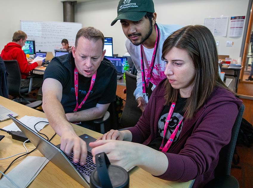 Students work in front of a laptop.