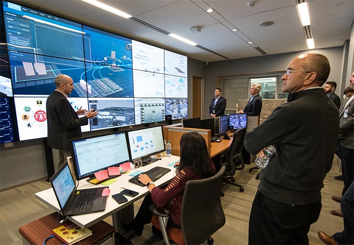 A group of people watch a presentation